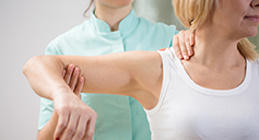 doctor examining lady with shoulder pain